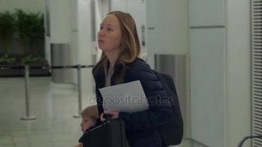Oğlu bir Havaalanı'nda yatılı bir kapısı olan bir genç kadın görüntüsünü Slowmotion