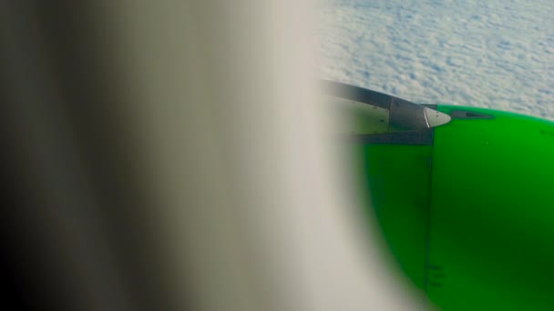 Вид из окна самолета на клоунов с зеленым двигателем самолета на заднем плане — стоковое видео