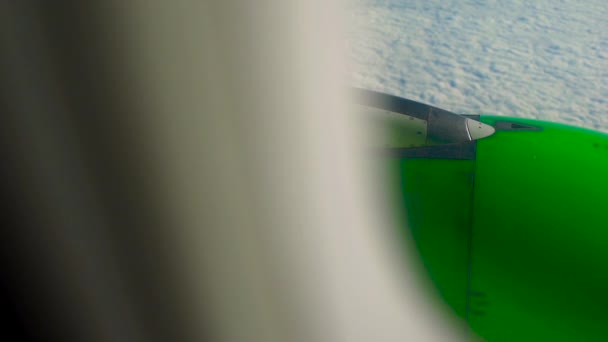 Vue depuis une fenêtre d'un avion sur des clowds avec un moteur d'avion vert en arrière-plan — Video