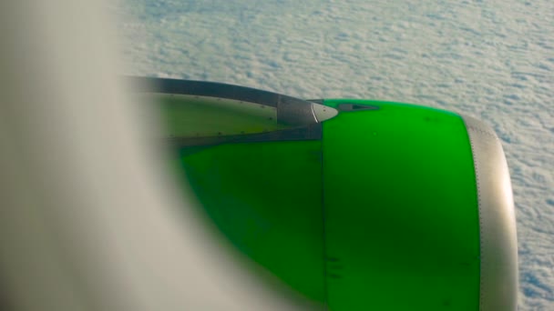 Blick aus dem Fenster eines Flugzeugs auf Wolken mit grünem Flugzeugmotor im Hintergrund — Stockvideo
