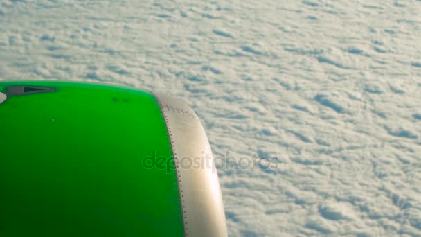 Vue depuis une fenêtre d'un avion sur des clowds avec un moteur d'avion vert en arrière-plan — Video