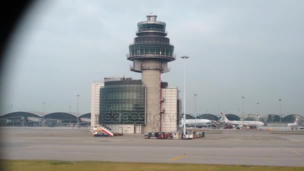 Girato dall'interno di un aeroplano - la telecamera si inclina dalla torre di controllo dell'aeroporto alla pista — Video Stock