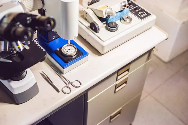 A sample preparation table in a laboratory with an optical microscope, ultrasonic cutter system and precision micrometer grinder polishing machine — Stock Photo, Image