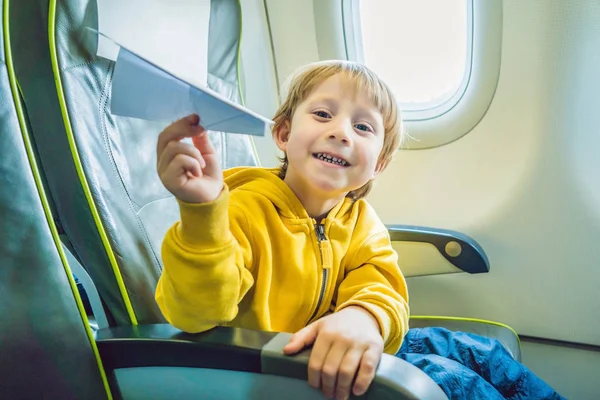 小さな男の子がバカンス飛行商業ジェット機の飛行機の紙飛行機で遊ぶ — ストック写真