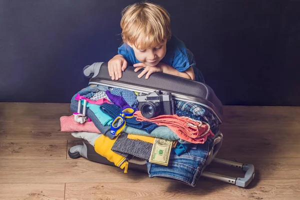 男の子の赤ちゃんと旅行かばん。子供と荷物満載の休暇のための服、子供と家族旅行の完全な — ストック写真