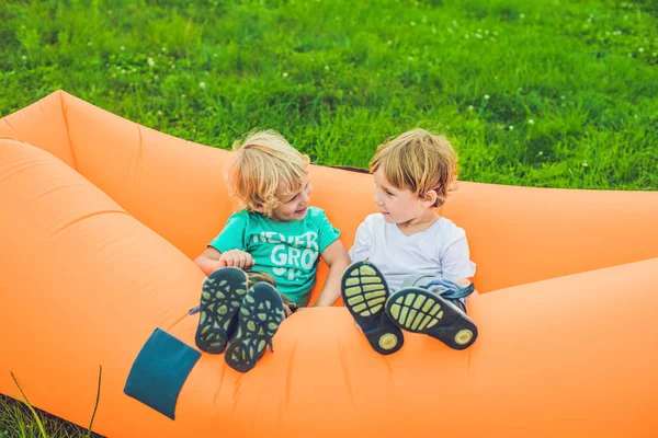 Zwei süße Jungen ruhen sich auf einem Luftsofa im Park aus. — Stockfoto