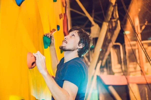Hombre escalador en pared de escalada artificial en el gimnasio de bouldering — Foto de Stock
