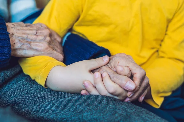 Las manos de un anciano y las manos de un niño, la continuidad de generaciones, el cuidado de los ancianos — Foto de Stock