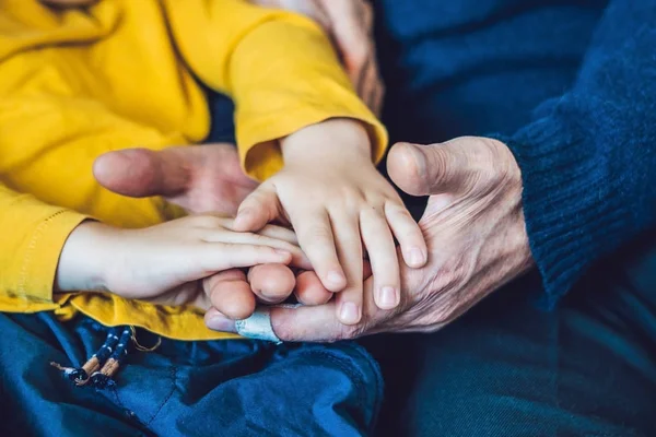 Руки пожилого человека и руки ребенка, афера — стоковое фото