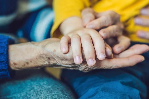 Mãos de uma velha e um jovem. Cuidar dos idosos. c) — Fotografia de Stock