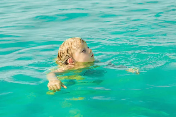 Ragazzo che nuota nel mare tropicale blu — Foto Stock