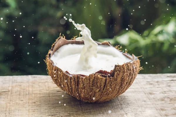 Frutta Cocco Spruzzi Latte Suo Interno Uno Sfondo Una Palma — Foto Stock