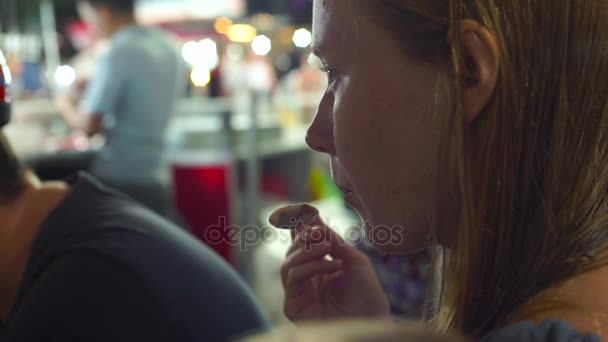 アジアのナイト マーケットで若い女性が手作りアイスクリームを食べる — ストック動画