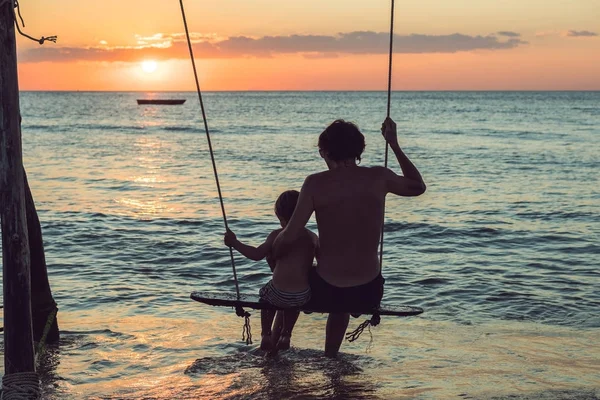 Silhouet Van Vader Zoon Spelen Schommel Zonsondergang Achtergrond — Stockfoto