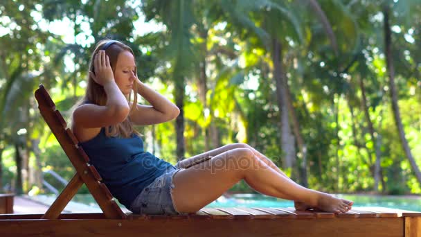 Gelukkige Vrouw Ontspannen Buurt Van Zwembad Met Oordopjes Naar Streaming — Stockvideo