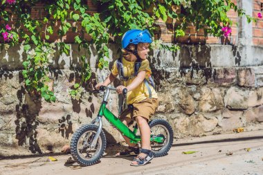Küçük çocuk bir bisiklet üzerinde. Hareket, bulanık bir driveway hareket üzerinde yakaladı. Okul öncesi çocuğun ilk gün bisiklet. Hareket sevinç. Bir bisiklet sürme sırasında dengesini korumak küçük atlet öğrenir.