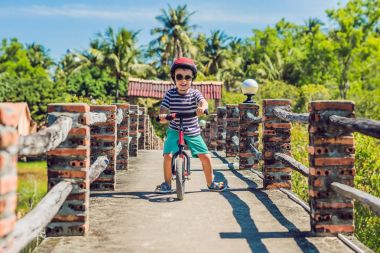 Küçük çocuk bir bisiklet üzerinde. Hareket, bulanık bir driveway hareket üzerinde yakaladı. Okul öncesi çocuğun ilk gün bisiklet. Hareket sevinç. Bir bisiklet sürme sırasında dengesini korumak küçük atlet öğrenir.