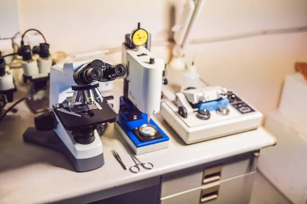 Sample preparation table in electron microscopy laboratory with an optical microscope, ultrasonic cutter system and precision micrometer grinder polishing machine