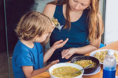 Anne ve oğlu yıkama el dezenfektanı kullanarak kafede jel.