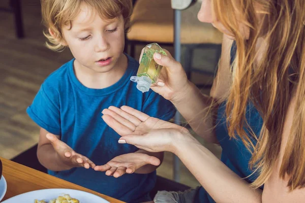 Matka Syn Pomocí Mytí Ruky Sanitizer Gelu Kavárně — Stock fotografie