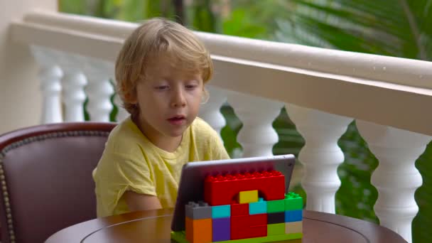 Arkadaşlar ve aile ile bir tablet ve kablosuz kulaklık kullanarak video arama üzerinde konuşurken tropik çocukta — Stok video