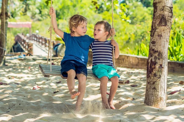 Двоє Маленьких Блондинок Розважаються Гойдалках Тропічному Піщаному Узбережжі — стокове фото