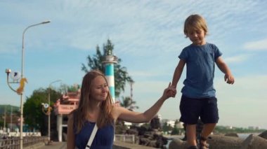 Genç kadın ve oğlu Dinh Cau deniz feneri sembolü ada Phu Quoc, Vietnam yürüyüş