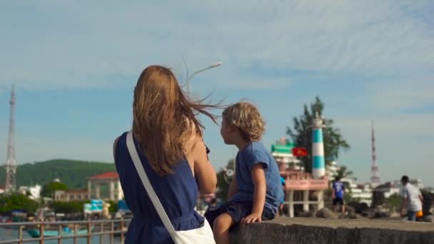 若い女性と彼女の息子が歩き回る島フーコック島のカウ灯台シンボル — ストック動画