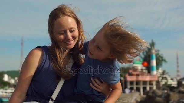 Junge Frau und ihr Sohn zu Fuß um dinh cau Leuchtturm Symbol der Insel phu quoc, Vietnam — Stockvideo