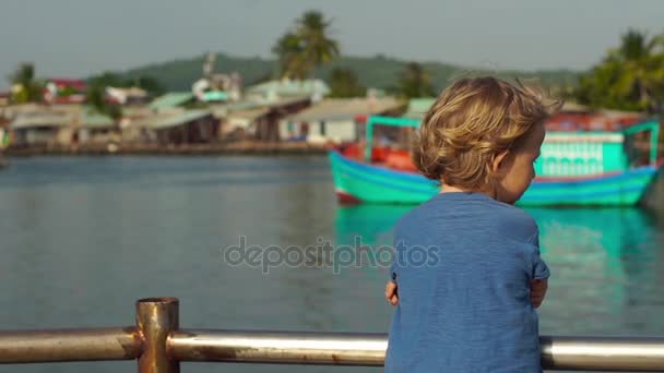 Μικρό αγόρι το περπάτημα γύρω από το νησί Phu Quoc, το Βιετνάμ σύμβολο Dinh Cau Φάρος — Αρχείο Βίντεο