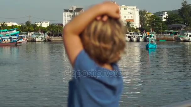 Маленький мальчик ходит вокруг маяка Динь Цау символ острова Фу Куок, Вьетнам — стоковое видео