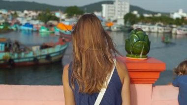 Genç kadın ve oğlu Dinh Cau deniz feneri sembolü ada Phu Quoc, Vietnam yürüyüş