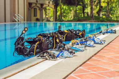 Equipment for diving is on the edge of the pool, ready for a lesson. clipart