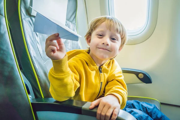 小さな男の子は商業ジェット機の飛行機の紙飛行機で遊ぶ — ストック写真