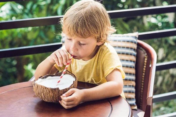 Menino bebe leite de coco caseiro de meio coco — Fotografia de Stock