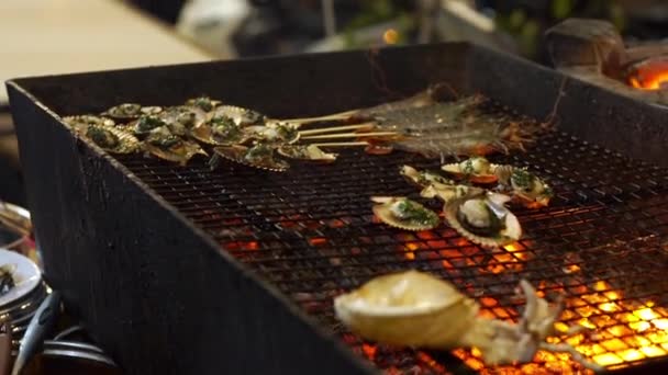 Slowmotion tiro de um processo de cozinhar frutos do mar em um churrasco em um mercado noturno asiático — Vídeo de Stock