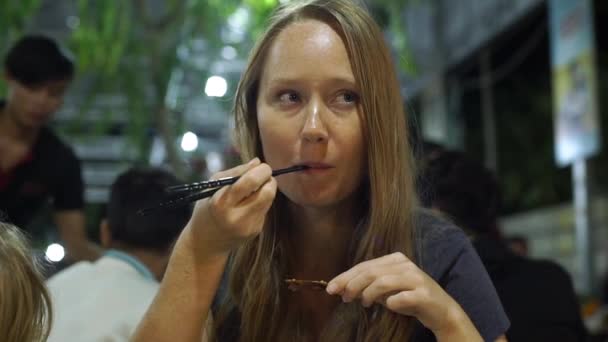 Tikje schot van een jonge vrouw en haar zoon eten in het café van een Aziatische zeevruchten — Stockvideo