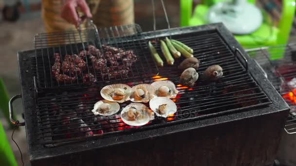 Медленная съемка процесса приготовления морепродуктов на барбекю на азиатском ночном рынке — стоковое видео