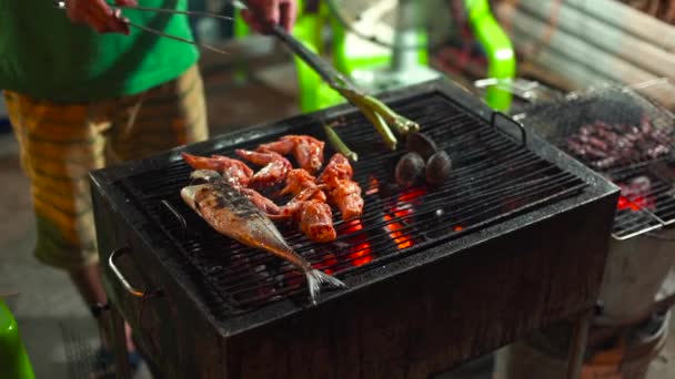 Slowmotion tiro de um processo de cozinhar frutos do mar em um churrasco em um mercado noturno asiático — Vídeo de Stock