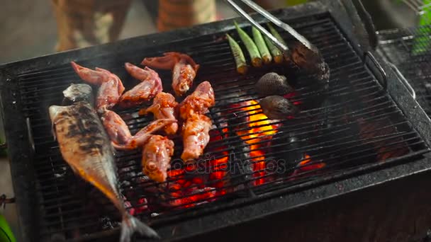 Lenta toma de un proceso de cocinar mariscos en una barbacoa en un mercado nocturno asiático — Vídeos de Stock