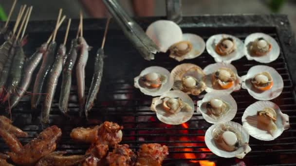 Медленная съемка процесса приготовления морепродуктов на барбекю на азиатском ночном рынке — стоковое видео