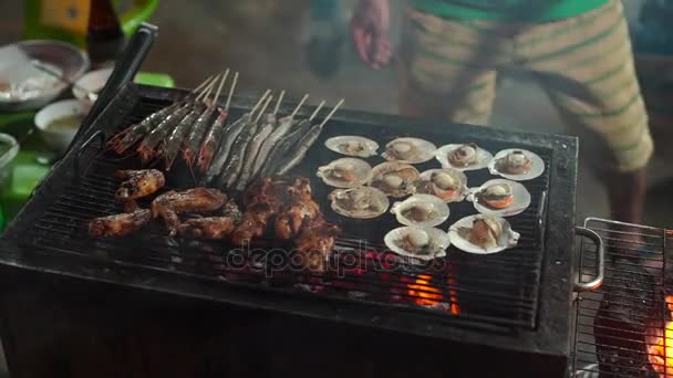 Lenta toma de un proceso de cocinar mariscos en una barbacoa en un mercado nocturno asiático — Vídeo de stock