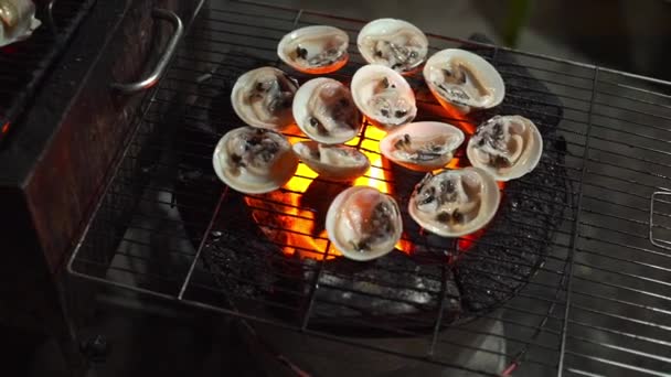 Lenta toma de un proceso de cocinar mariscos en una barbacoa en un mercado nocturno asiático — Vídeo de stock