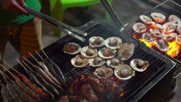 Slowmotion tiro de um processo de cozinhar frutos do mar em um churrasco em um mercado noturno asiático — Vídeo de Stock