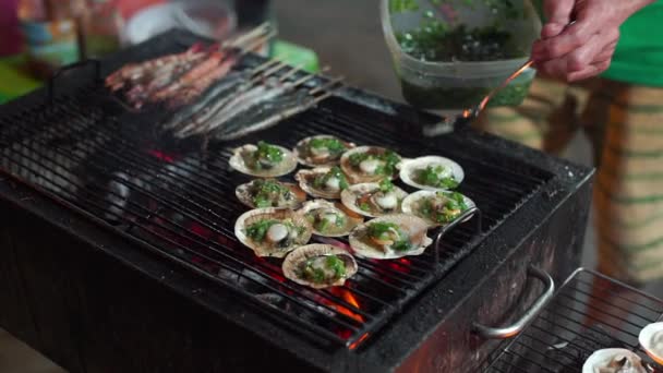 Lenta toma de un proceso de cocinar mariscos en una barbacoa en un mercado nocturno asiático — Vídeo de stock