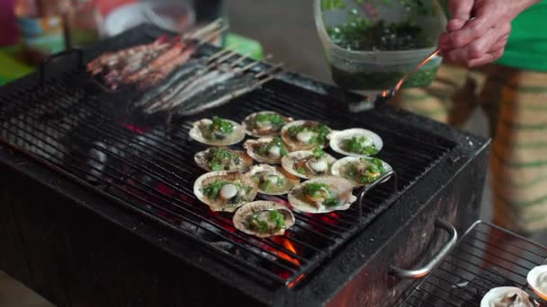 Lenta toma de un proceso de cocinar mariscos en una barbacoa en un mercado nocturno asiático — Vídeos de Stock