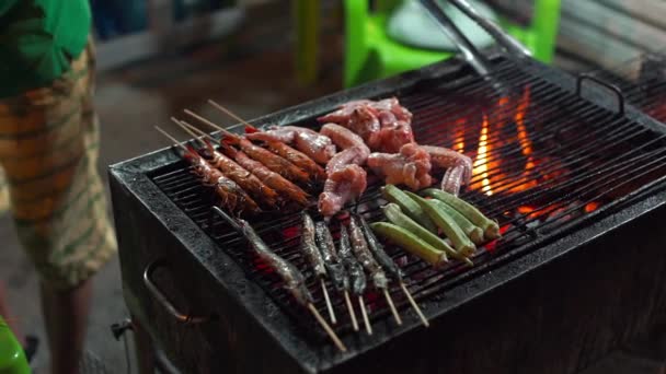 Slowmotion tiro de um processo de cozinhar frutos do mar em um churrasco em um mercado noturno asiático — Vídeo de Stock