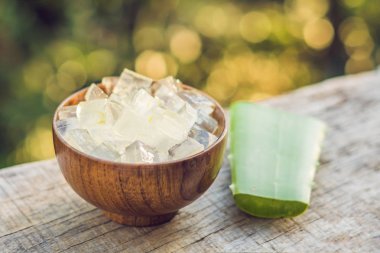 Aloe vera ve aloe küpleri ahşap bir kase içinde. Aloe Vera jel neredeyse gıda, ilaç ve güzellik sektöründe kullanımı