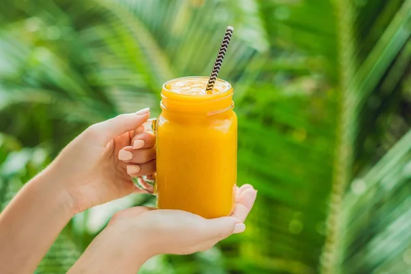 Mango smoothie in a glass Mason jar and mango on a green backgro — Stock Photo, Image