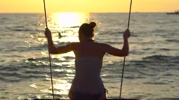 Mulher feliz balançando em um balanço de corda com um paraíso mar tropical no fundo — Vídeo de Stock